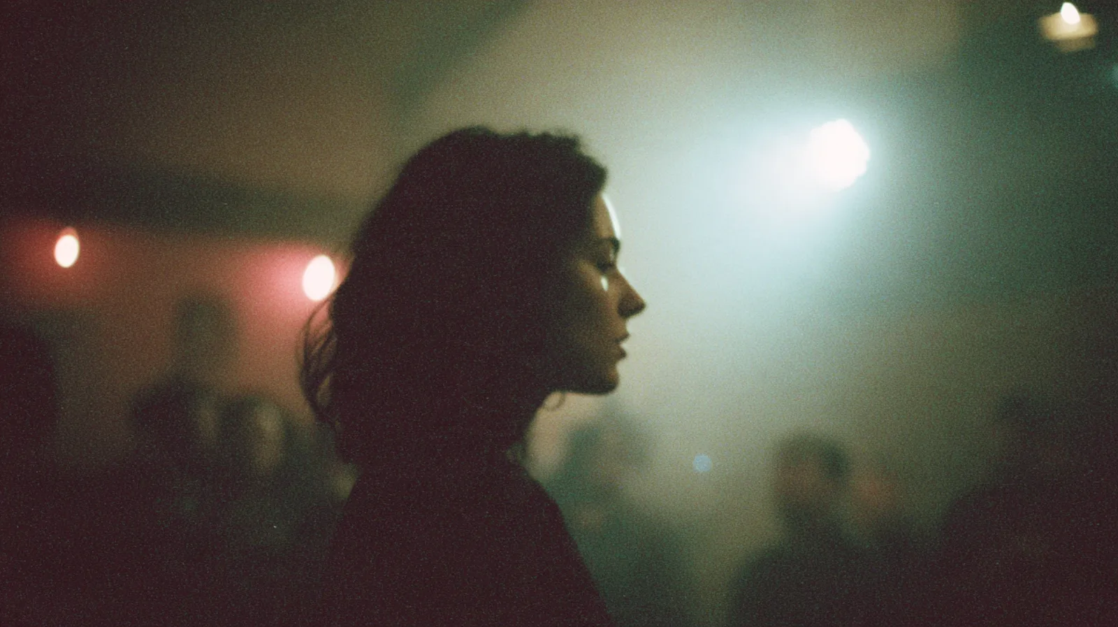 Profile of a woman lit by a soft rim of light in a dim, hazy room
