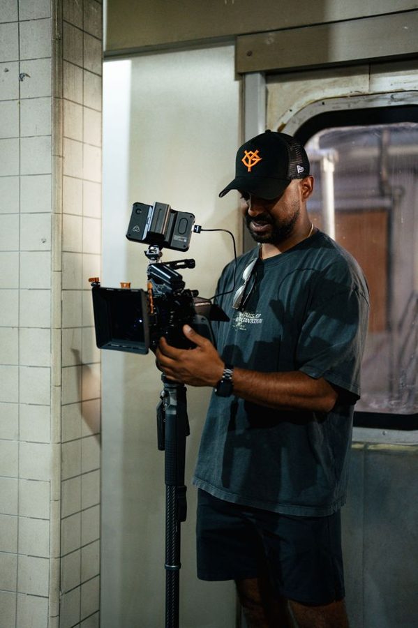 Operator holding a rigged cinema camera in a tiled hallway